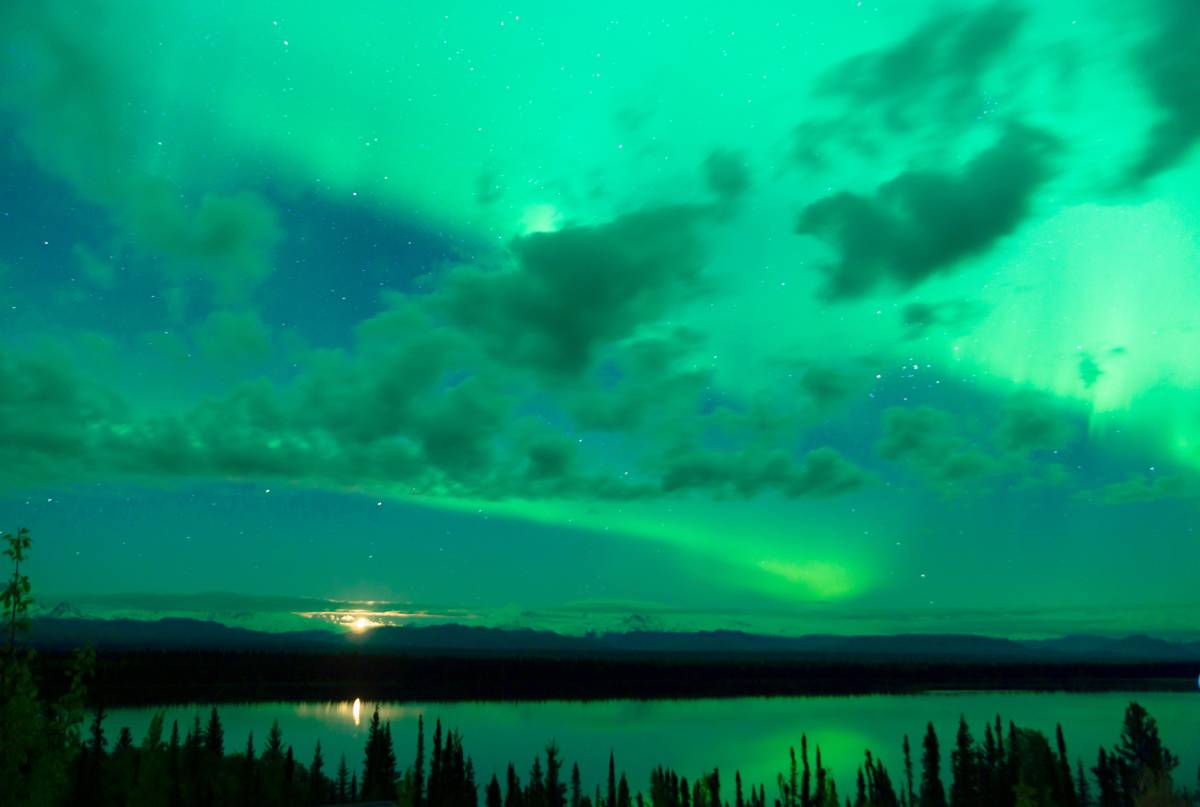 The Aurora Borealis peeking through the clouds in Alaska