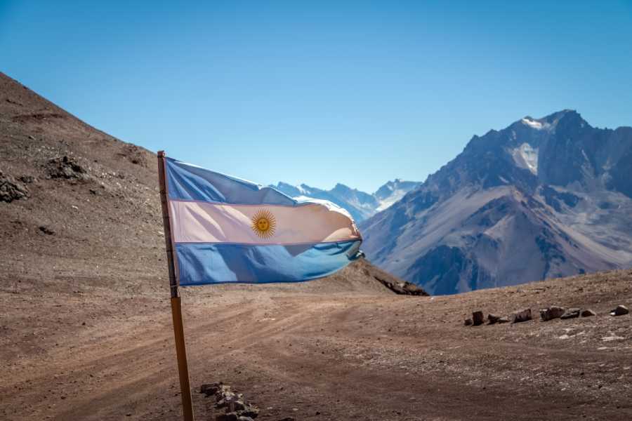 Argentina flag blowing in wind on mountain