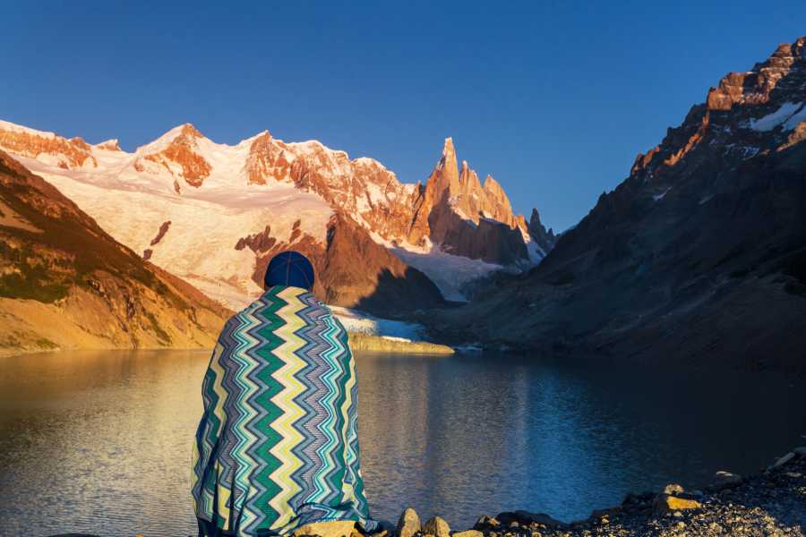 sitting by lake in front of mountains in Argentina