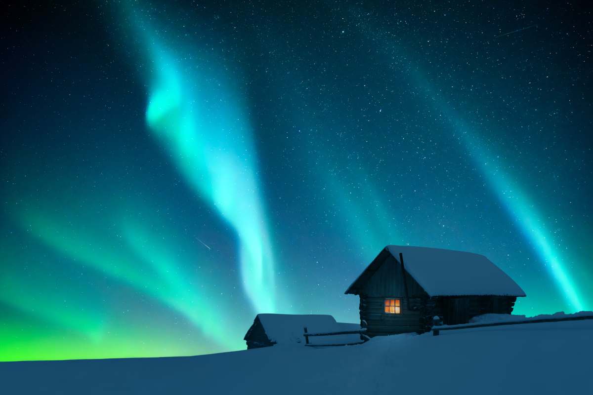 Alaska aurora borealis over log cabin