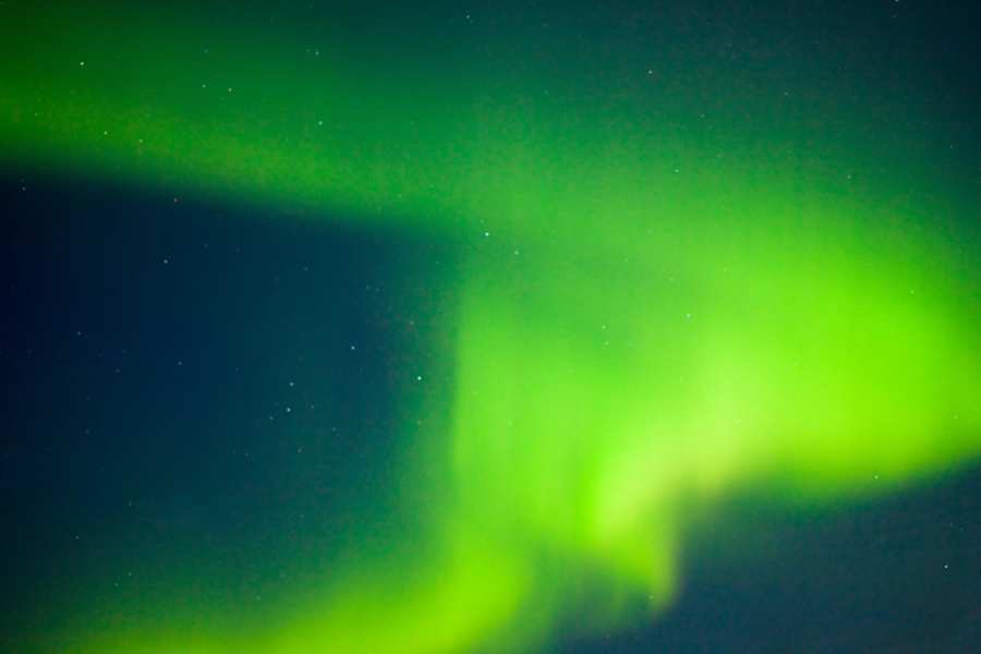 Bright green aurora borealis ribbons in Alaska sky