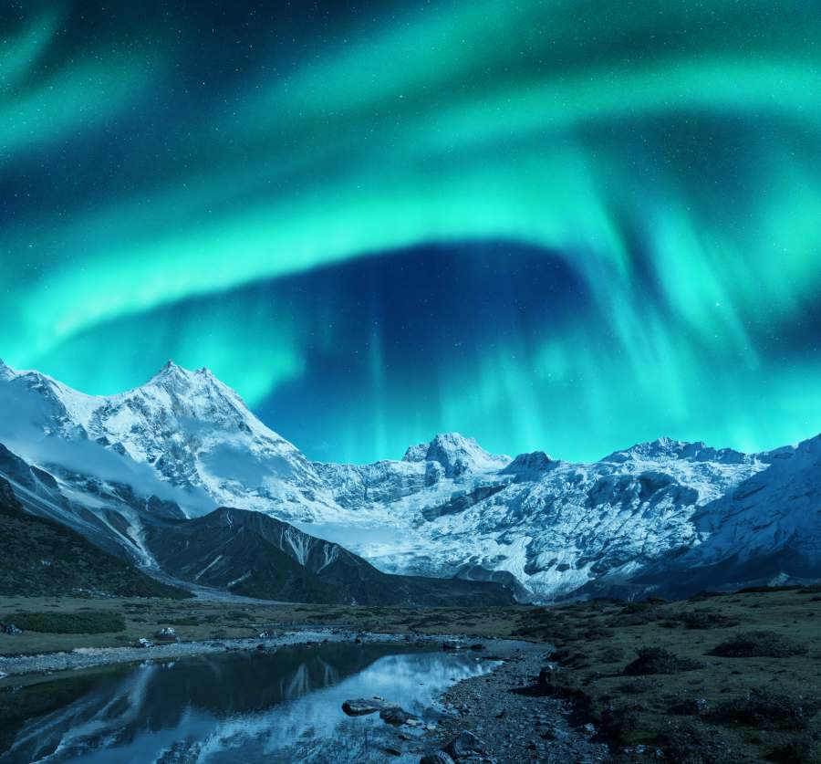 Aurora borealis over snow-covered mountains