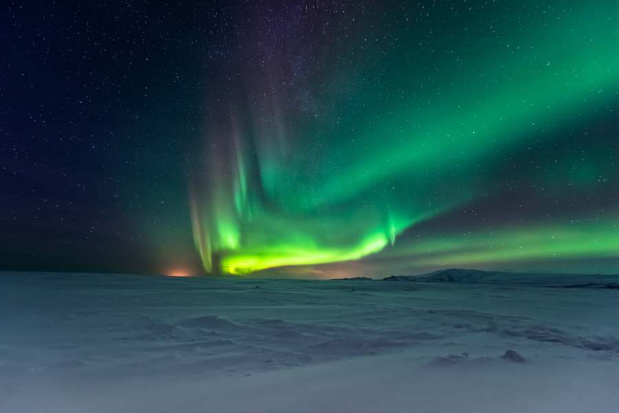 different shades of greens and purple northern ligths in snowcovered tundra Alaska
