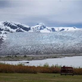 Witness the captivating grandeur of Alaskan glaciers, where these ancient ice formations tower over landscapes in glistening hues of bright blue.